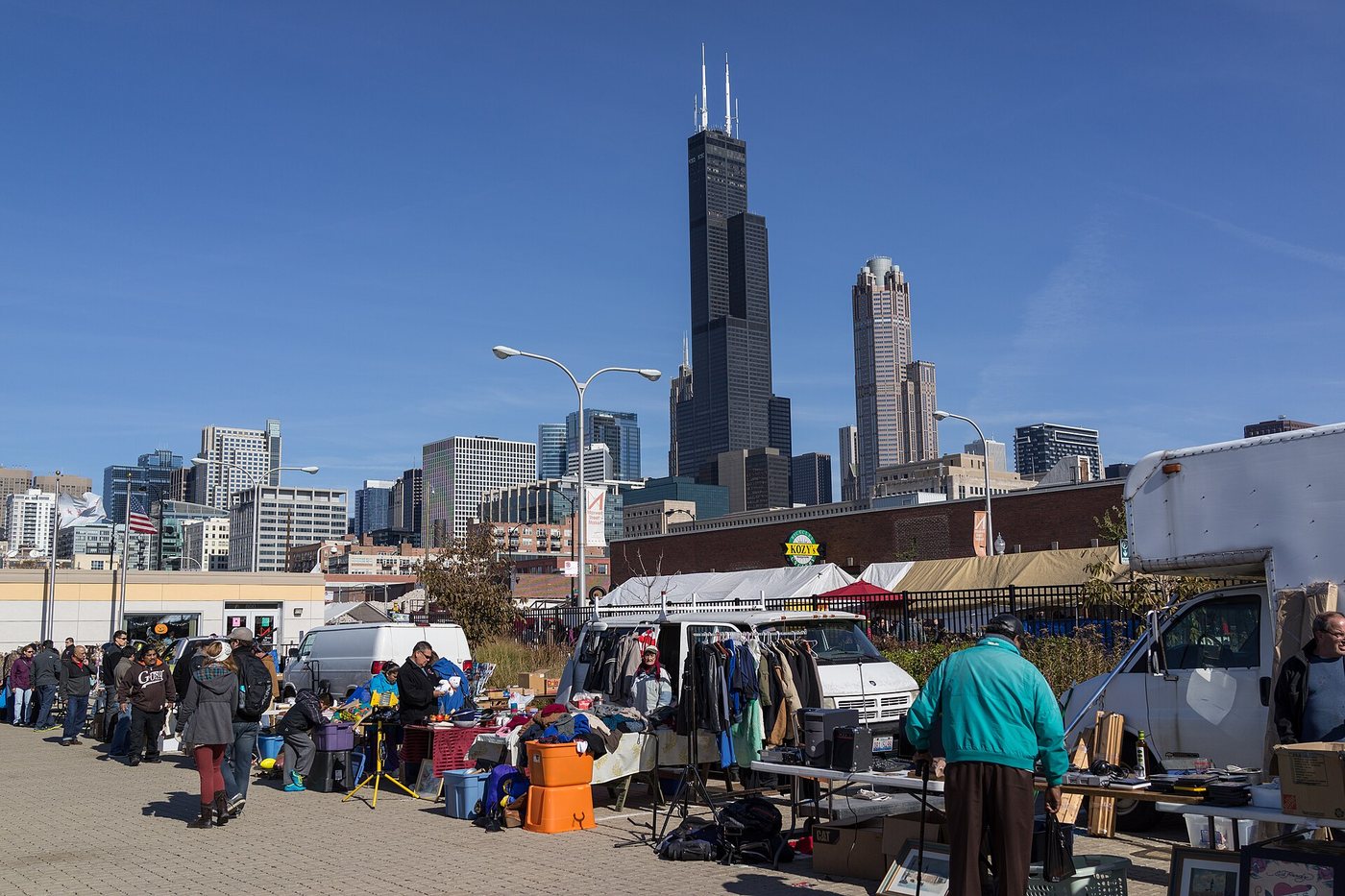 Stalls at Maxwell Street Market with the Chicago skyline behind them.