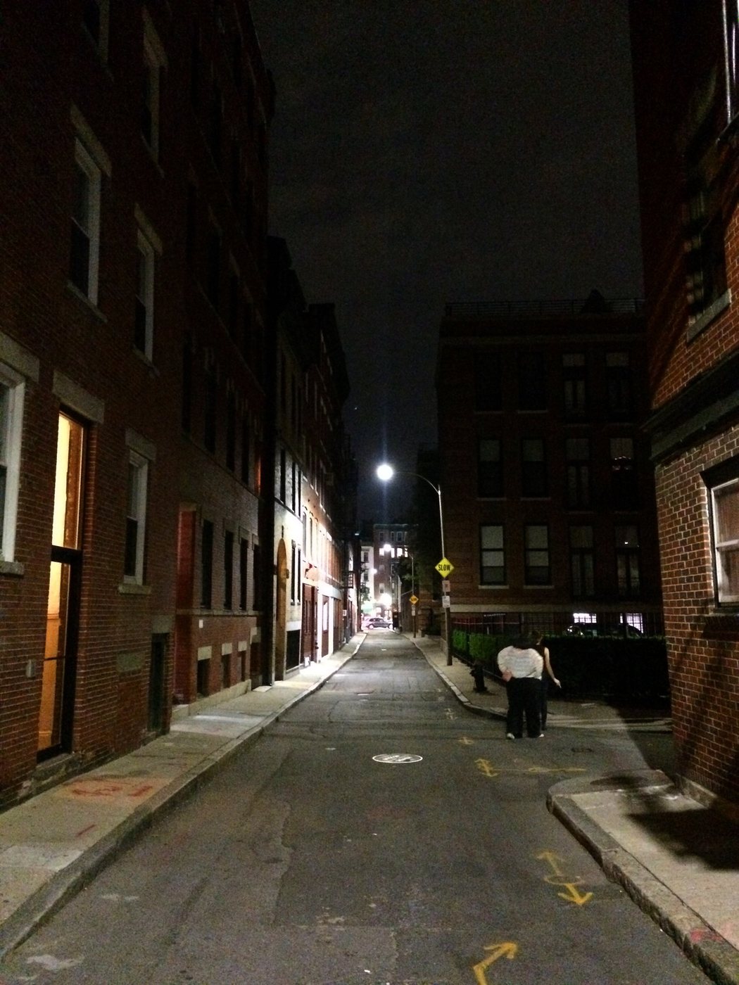 A narrow North End street photographed at night in Boston.