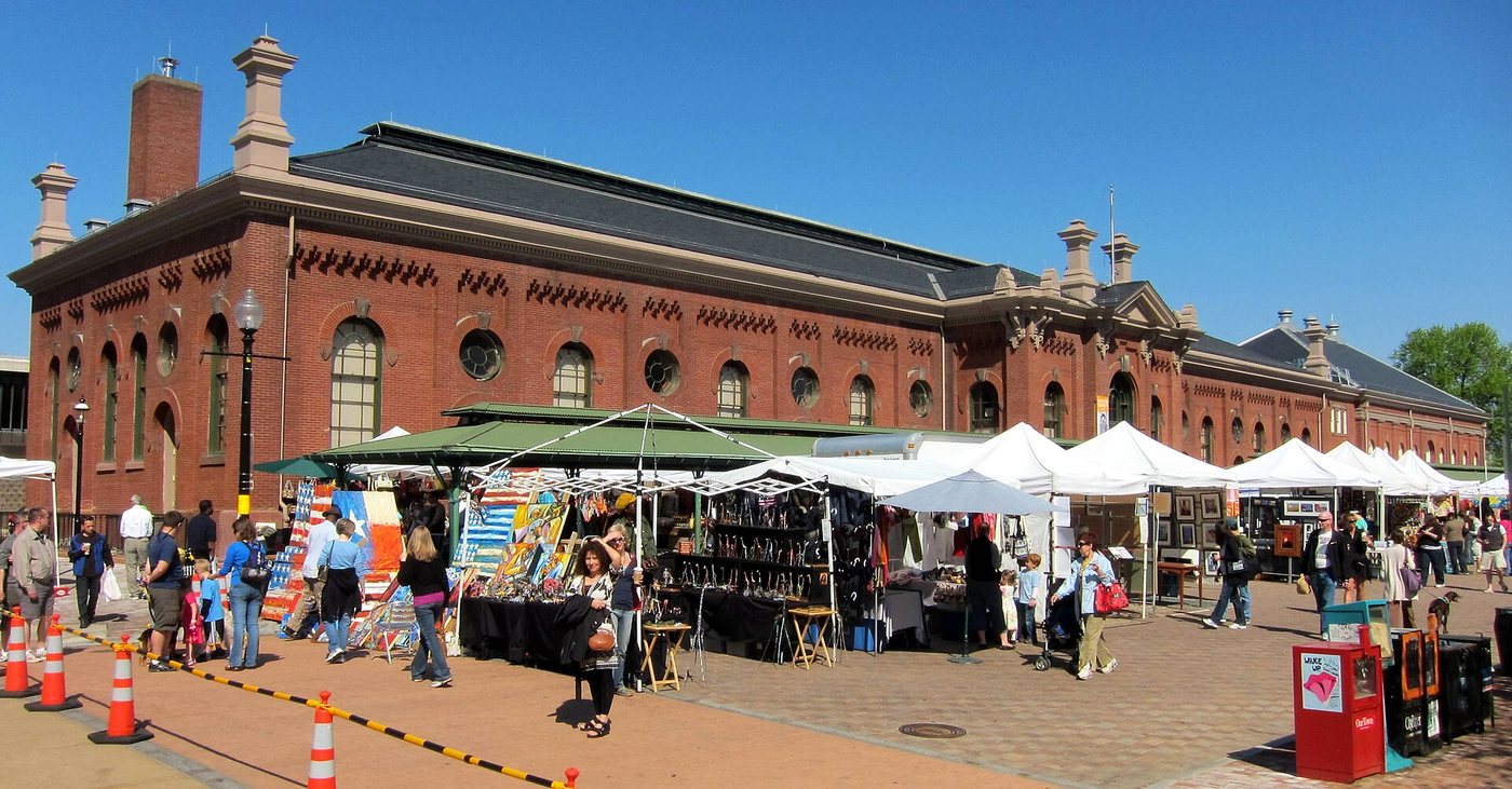 Outdoor stalls beside the brick Eastern Market building in Washington, DC.