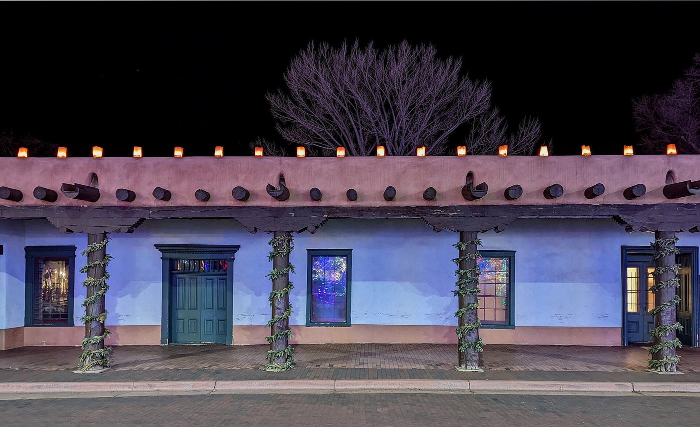 The long facade of the Palace of the Governors illuminated at night.