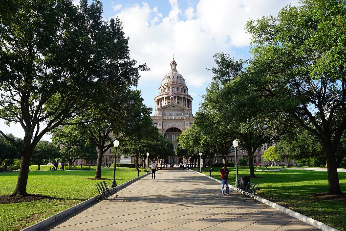 The Texas State Capitol at the end of a tree-lined approach in Austin.
