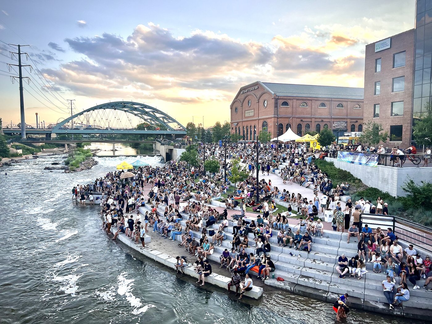 People gathered beside the water at Denver's Confluence Park.